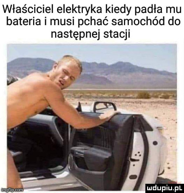właściciel elektryka kiedy padła mu bateria i musi pchać samochód do następnej stacji